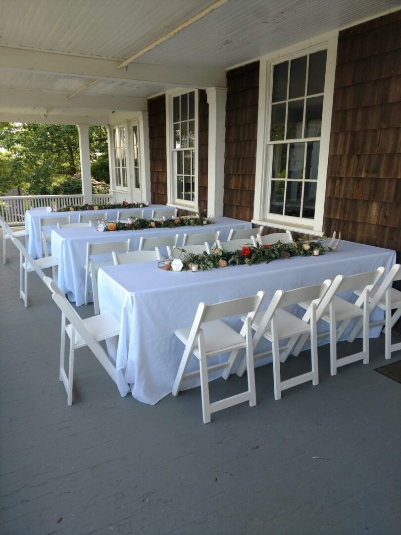 Three long tables with white table cloth setup